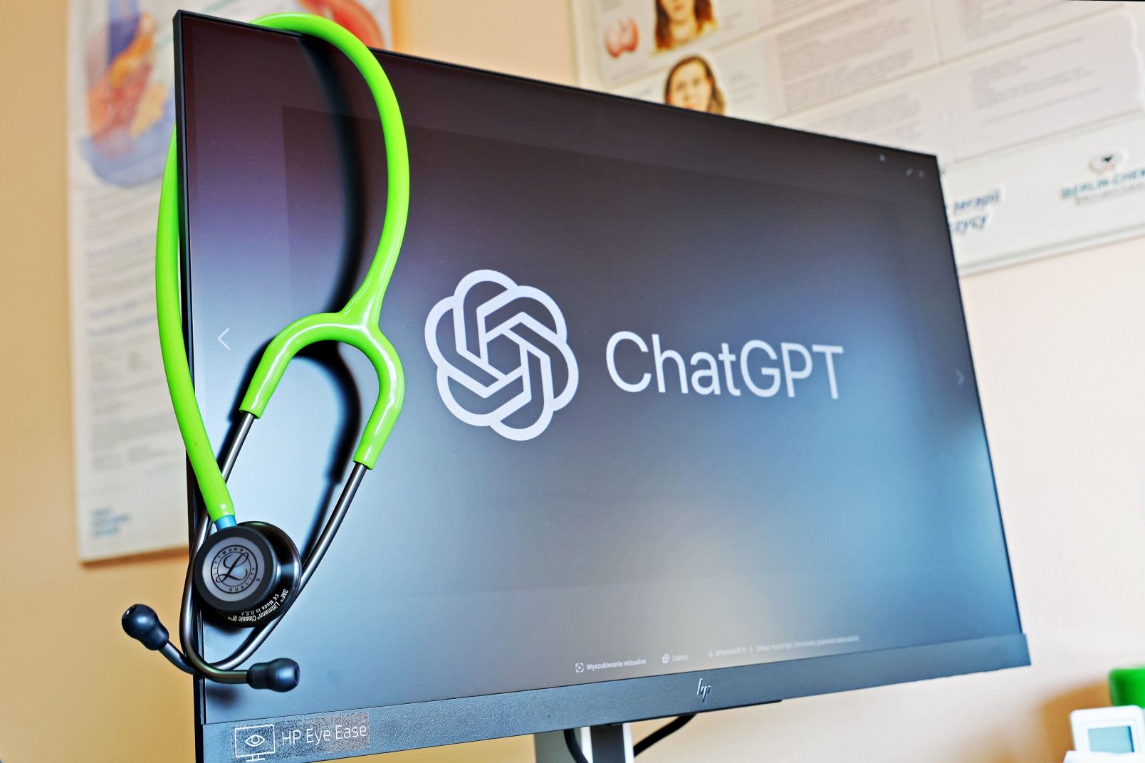 Monitor z napisem ChatGPT i przewieszonym przez niego zielonym stetoskopem
