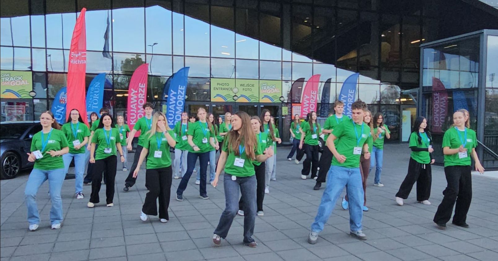 Halowe Mistrzostwa Europy Masters to okazja na ciekawe i wartościowe praktyki studentów i studentek z Wydziału Humanistycznego UMK Grupa młodych ludzi w zielonych koszulkach prezentuje układ taneczny