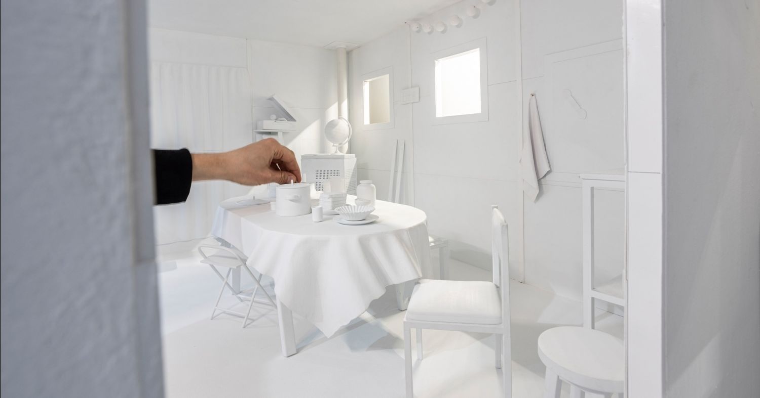 Autorem projektu artystyczno-badawczego "Oaza" jest dr Jakub Wawrzak z Katedry Grafiki na Wydziale Sztuk Pięknych UMK Makieta wnętrza domowej kuchni, skala pomniejszona, nakryty stół, na nim kuchenne sprzęty i naczynia, obok stoją krzesła