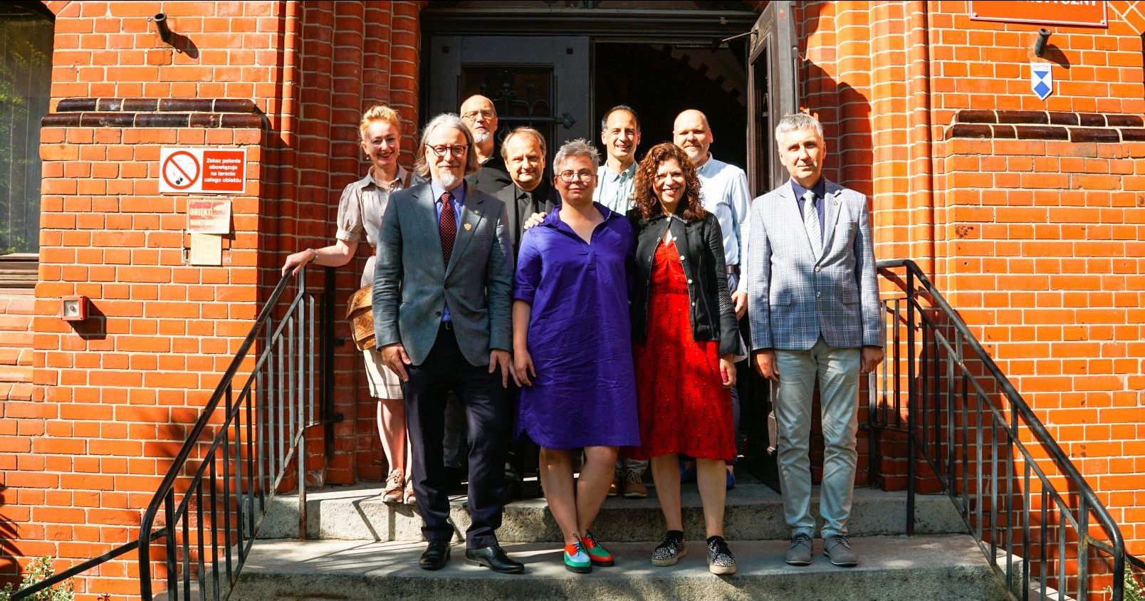 A group of people standing in a front of Collegium Maius