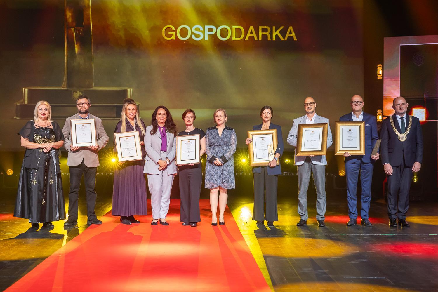 Laureaci i wyr&oacute;żnieni w kategorii "Gospodarka" pozują do wsp&oacute;lnego zdjęcia na scenie
