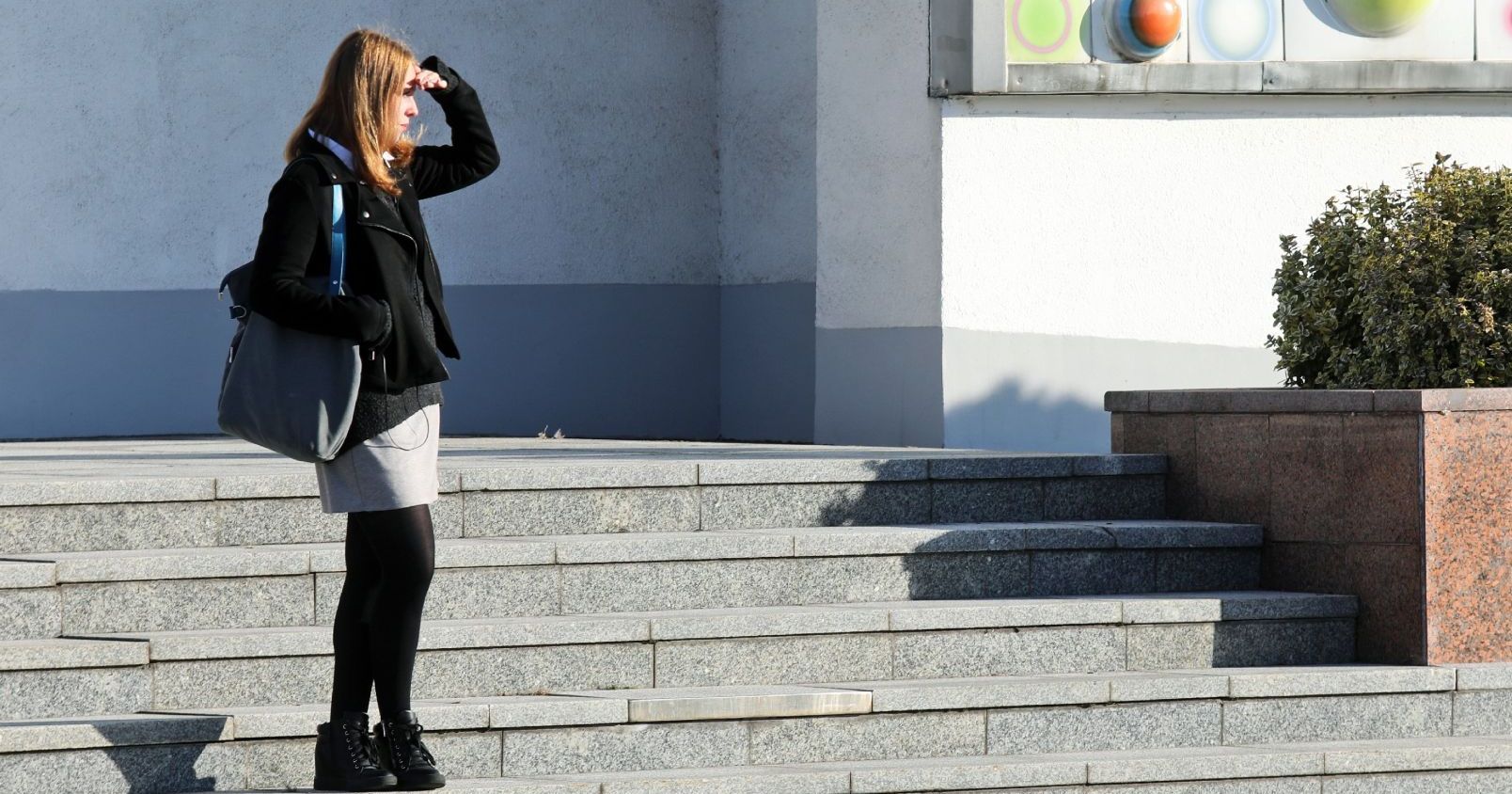Program MOST umożliwia wyjazd na semestr w innym mieście Dziewczyna stoi przed Aulą UMK, przykłada rękę do czoła, żeby osłonić oczy przed słońcem