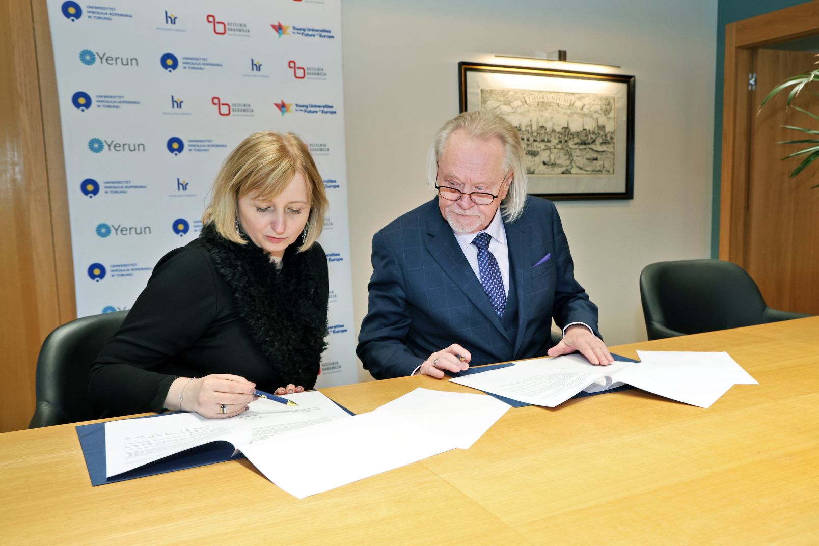 Dr Marlena Maślanka, dyrektorka Sieci Badawczej Łukasiewicz i prof. dr hab. Andrzej Tretyn podpisują dokumenty leżące na stole