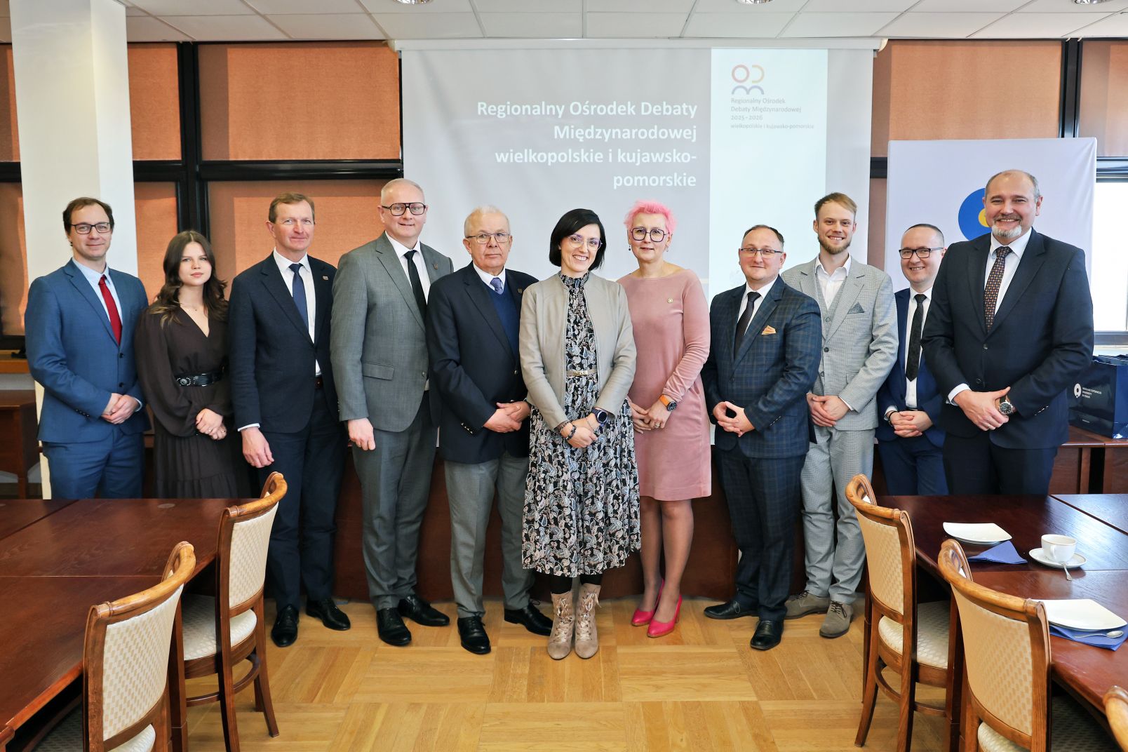 Kobiety i mężczyźni pozują do wsp&oacute;lnego zdjęcia ze spotkania