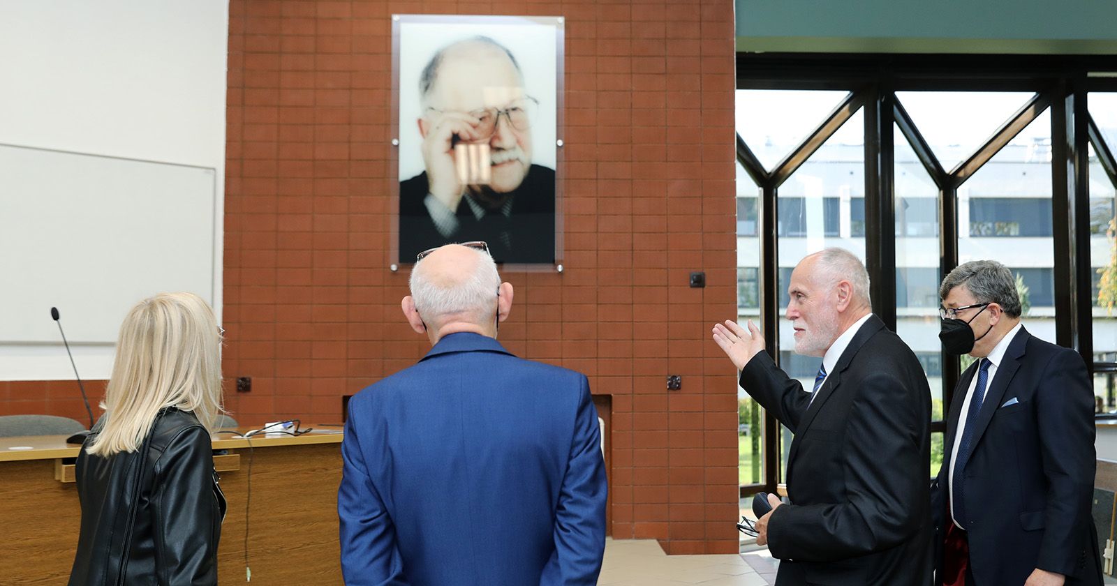 Czworo przedstawicieli władz Uniwersytetu i Wydziału Nauke Ekonomicznych i Zarządzania przed portretem prof. Sudoła, w sali, której patronem został