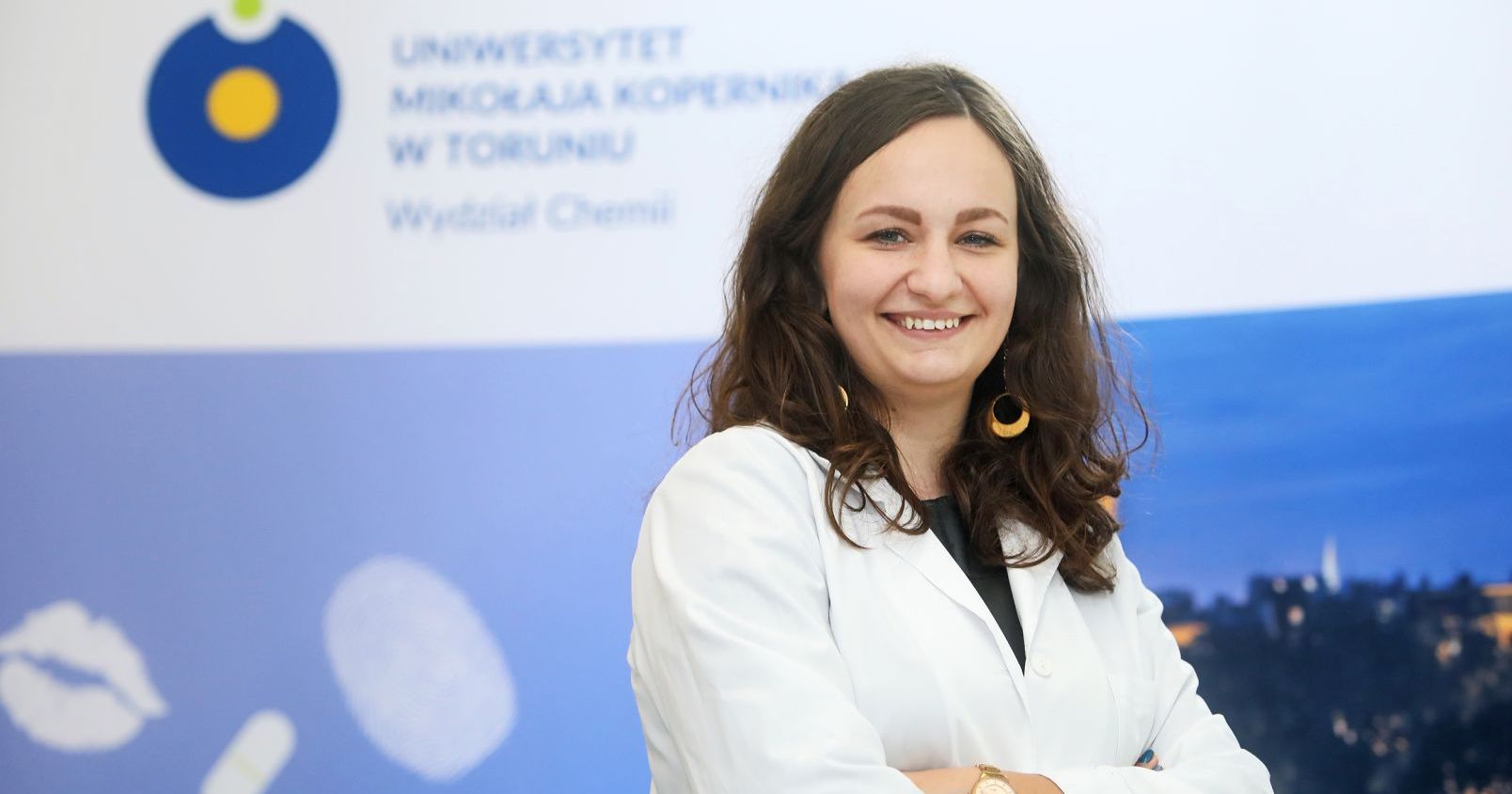 Dr Beata Kaczmarek-Szczepańska, kierowniczka zwycięskiego grantu w konkursie Tango V Młoda kobieta pozująca do zdjęcia, ubrana w biały fartuch