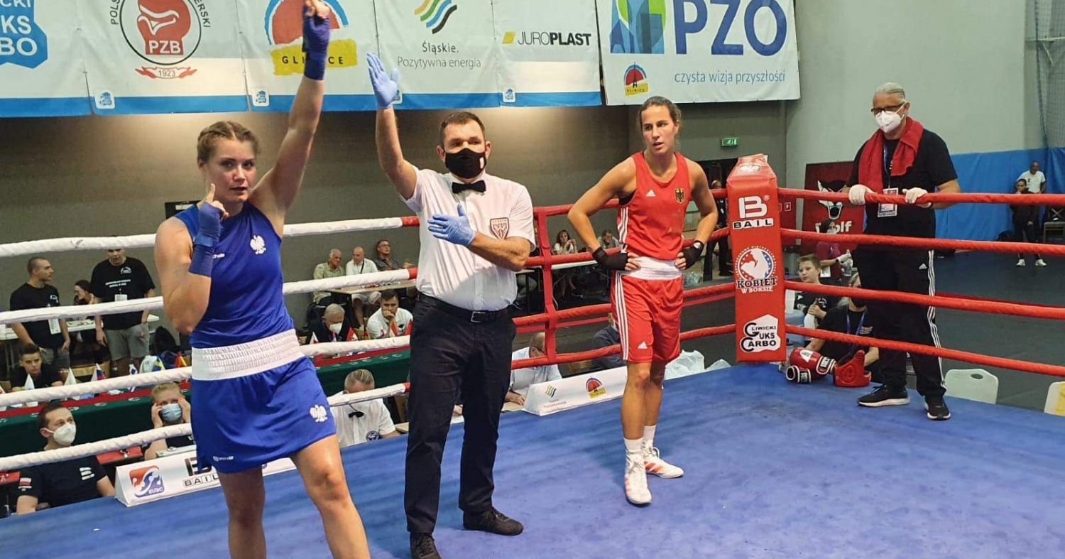  Aneta Rygielska na ringu bokserskim obok sędziego i swojej przeciwniczki