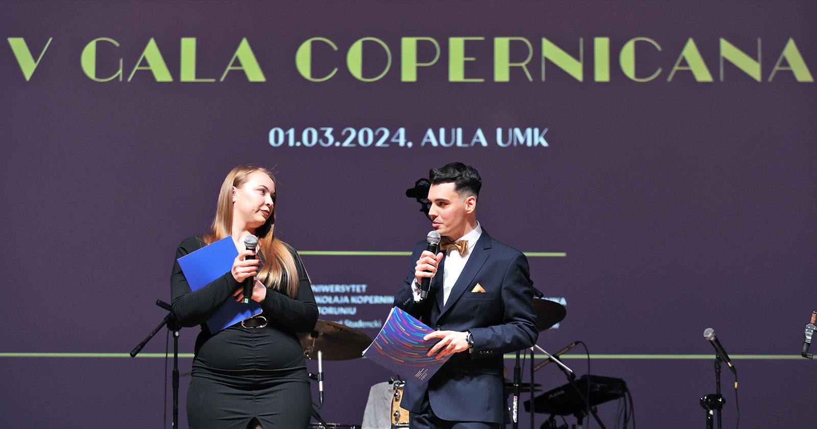 Galę poprowadzili Klaudia Krajnik i Kajetan Szmul Dwie osoby na scenie z mikrofonami, a nimi wyświetlony napis "V Gala Copernicana"