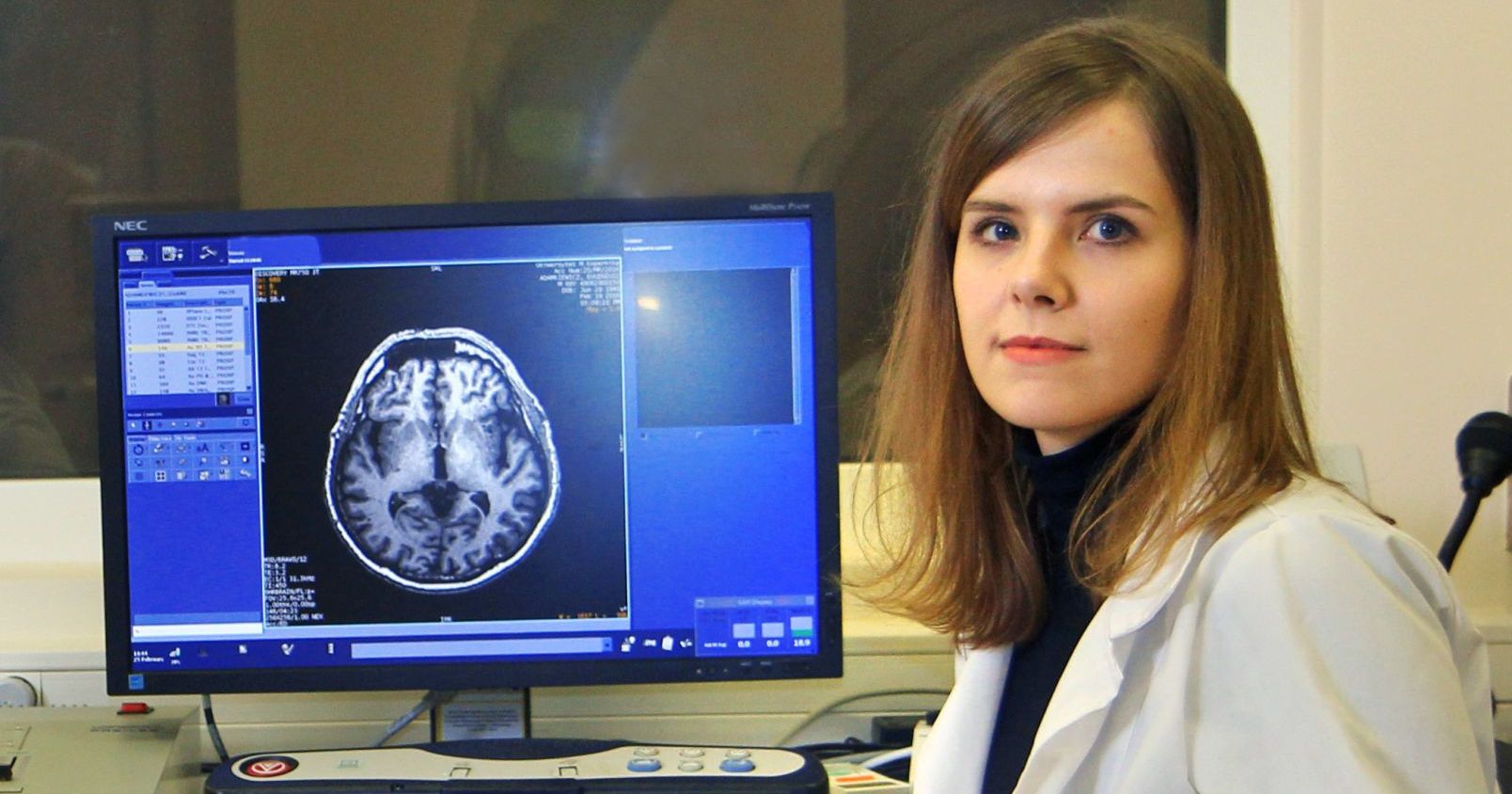 Dr Karolina Finc wygłosi referat podczas Lindau Nobel Laureate Meeting Po lewej stronie zdjęcia stoi monitor, na którym wyświetlony jest obraz mózgu. Po prawej stroniedr Karolina Finc
