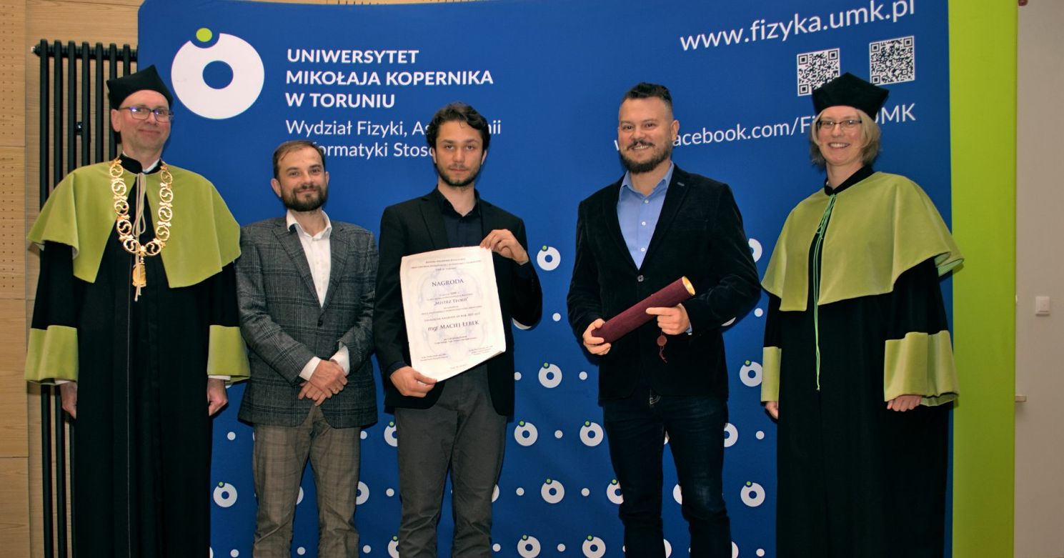 Laureatem pierwszej edycji konkursu Mistrz Teorii został Maciej Łebek Przy ściance z logo uniwersytetu stoi czterech mężczyzn i kobieta