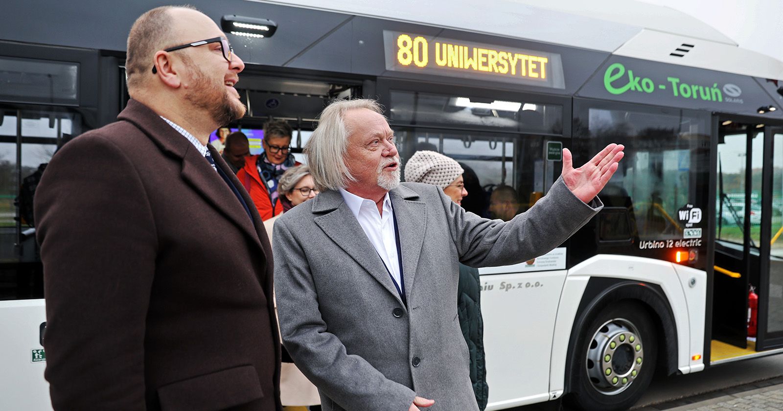 Na zdjęciu stoją od lewej Paweł Gulewski, prezydent Torunia i prof. dr hab. Andrzej Tretyn, rektor UMK. Za nimi stoi autobus elektryczny lini nr 80.