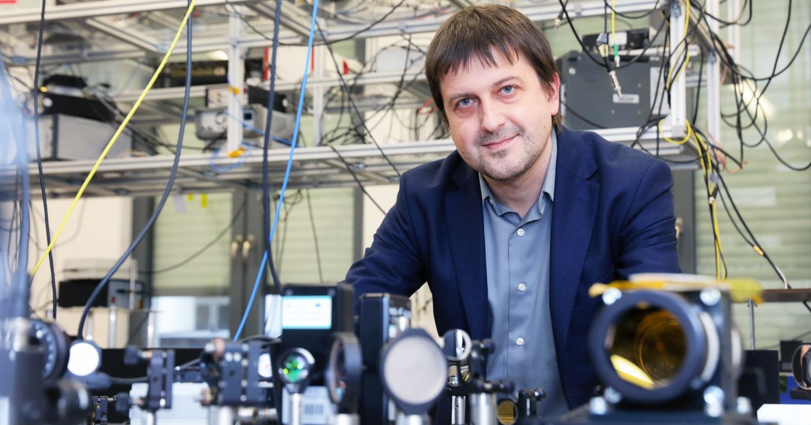 Prof. Piotr Masłowski wśród specjalistycznego sprzętu i kabli