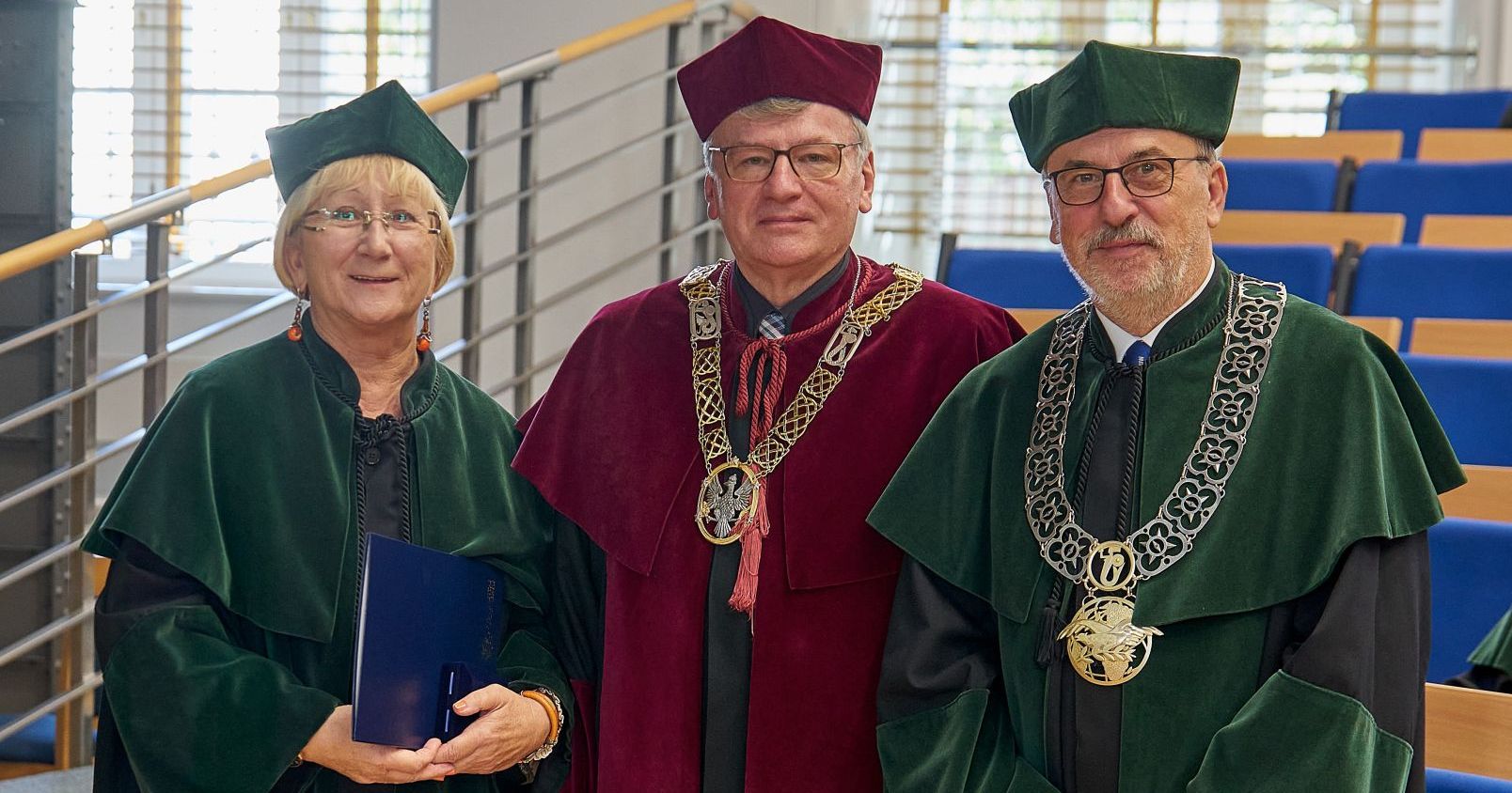 Prof. Daniela Szymańska wraz z prorektorem UW ds. badań prof. Zygmuntem Lalakiem i dziekanem Wydziału Geografii i Studiów Regionalnych UW prof. Maciejem Jędrusikiem Troje ludzi w togach pozuje do zdjęcia