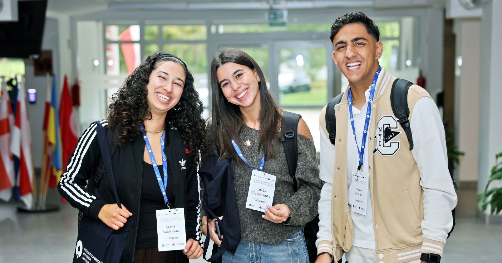 Three smiling students. They are participants in the YUFE summer school at Nicolaus Copernicus University