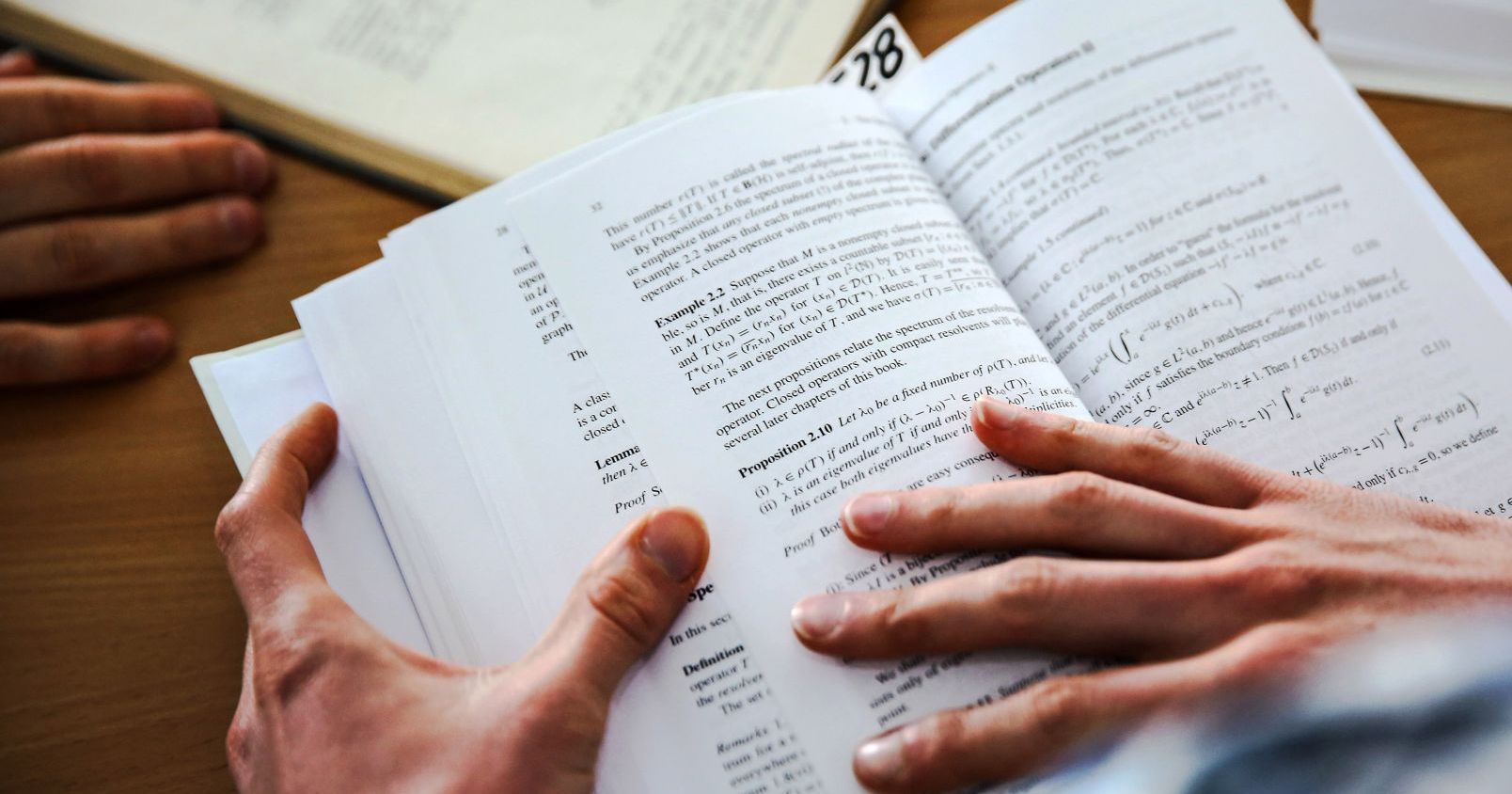 Dłonie trzymające otwartą książkę