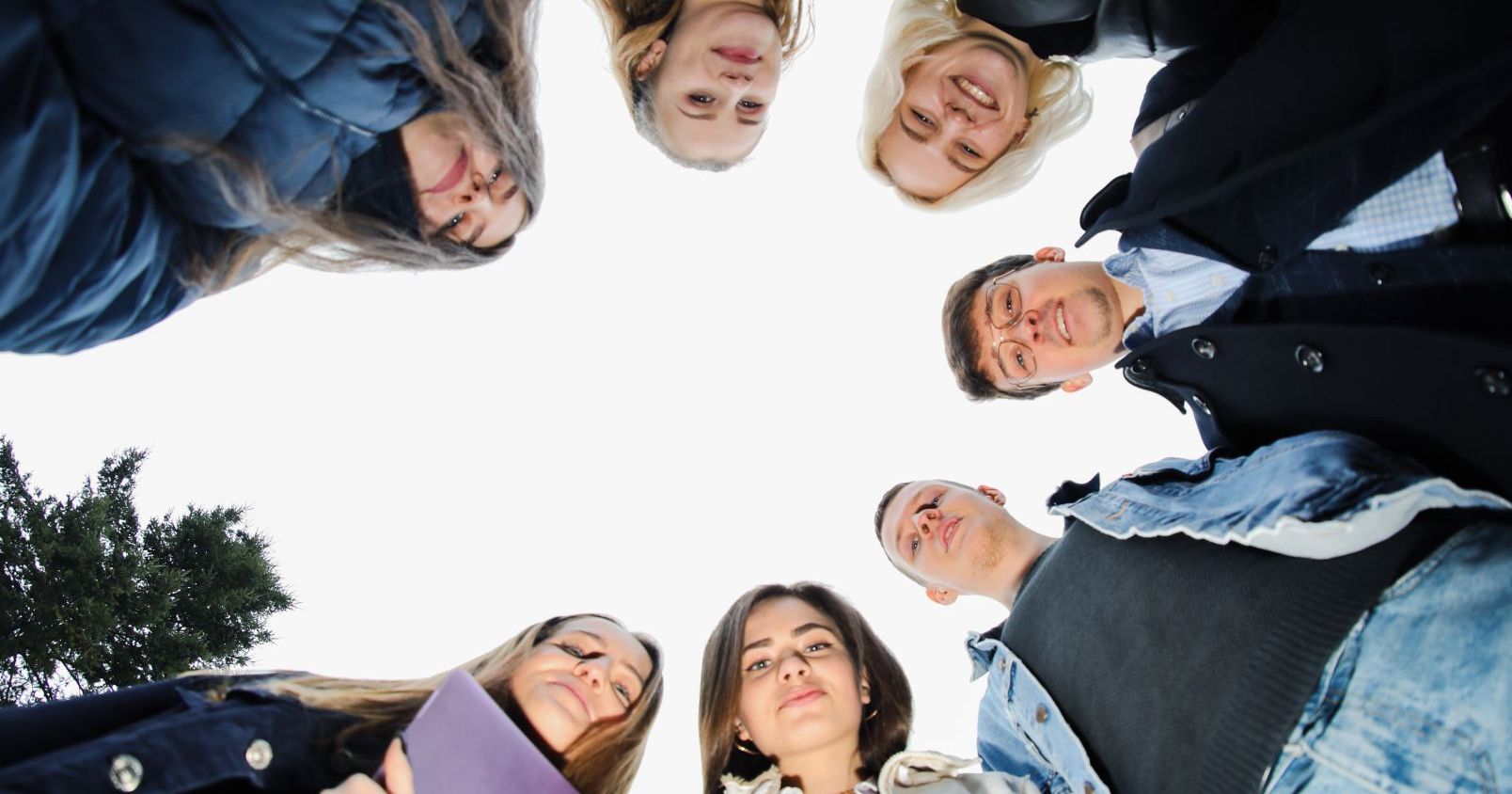 A group of students standing in circle, photo was taken from below