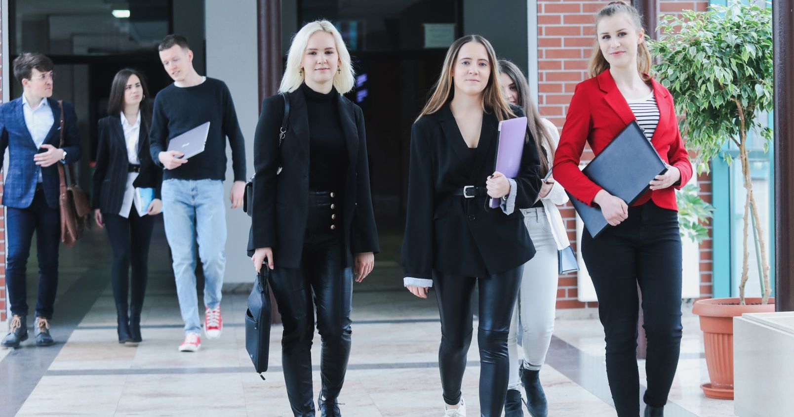  Group of students are going walks down the corridor towards the photographer