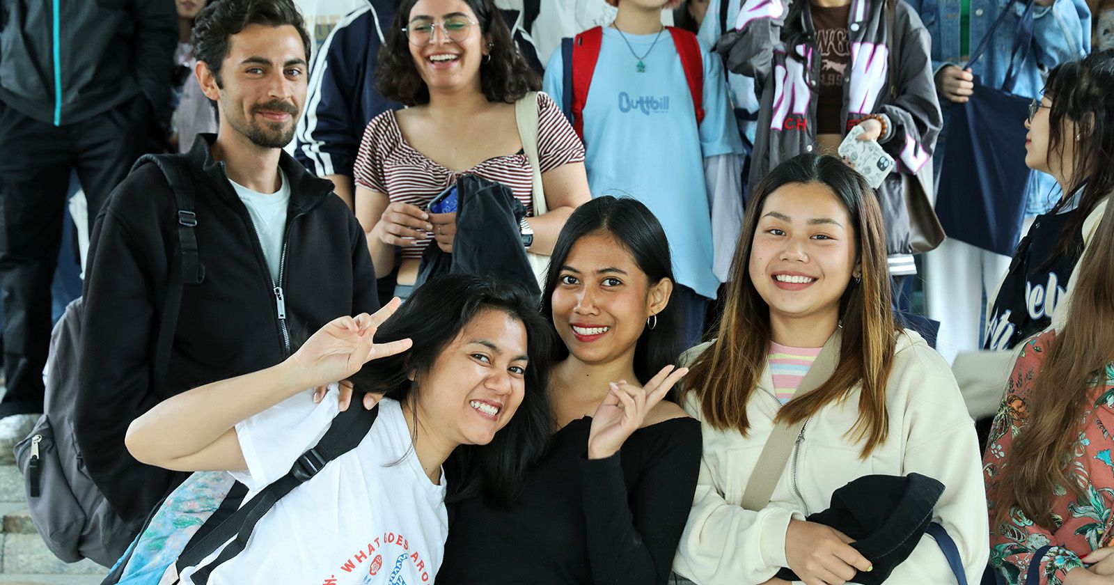  Grupa studentów i studentek zagranicznych pozujących do zdjęcia