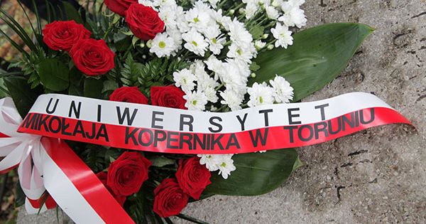  Wiązanka pogrzebowa ze wstęgą w kolorach białym i czerwonym oraz napisem "Uniwersytet Mikołaja Kopernika w Toruniu"